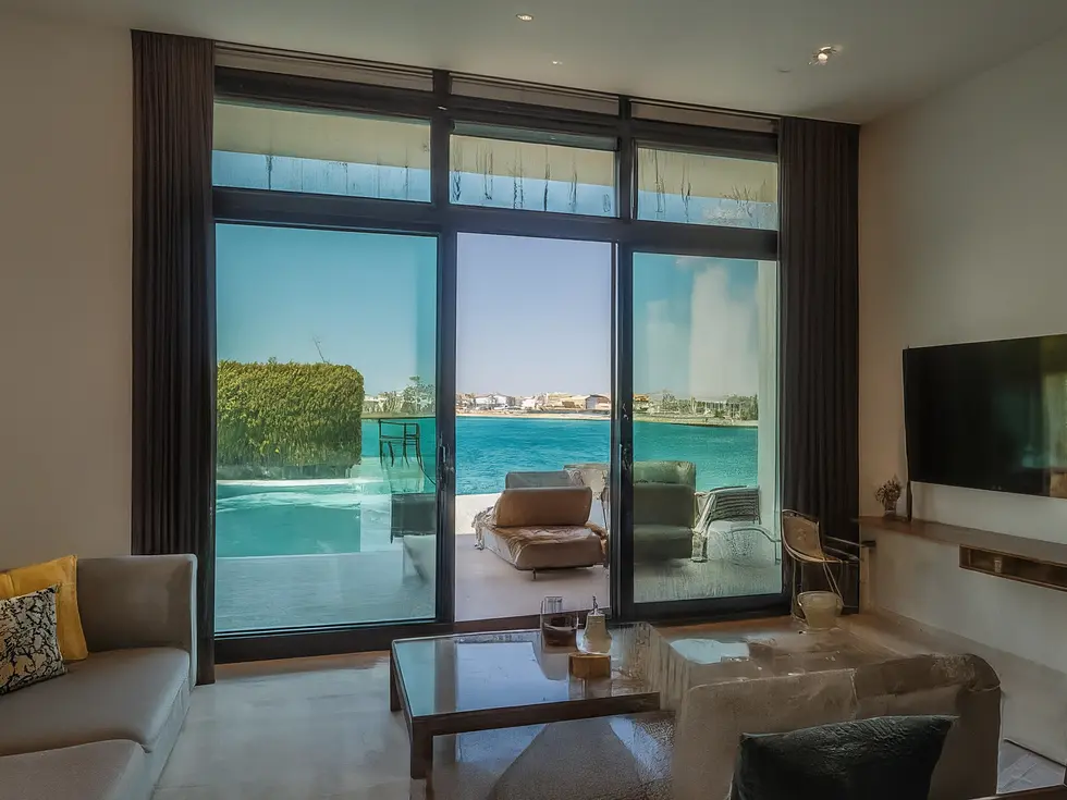 رجل أعمال يتفحص وثائق استثمارية أمام نموذج لمشروع عقاري فاخر في دبي